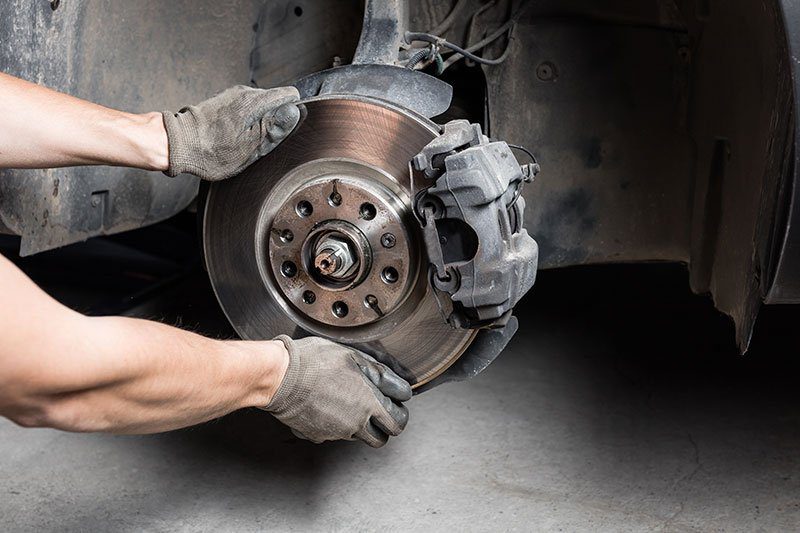 A person working on the brake of their car
